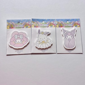 May include: Three colorful sticky note sets featuring Sanrio characters from the Fairy Town collection. The sets feature My Melody,  Keroppi, and  Badtz-Maru. Each set has the Everland Resort logo.