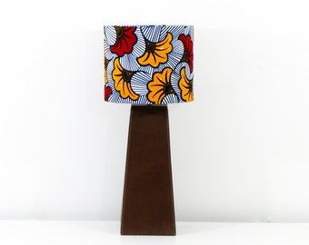 May include: A brown table lamp with a white, blue, yellow, and red patterned lampshade featuring stylized flower designs.