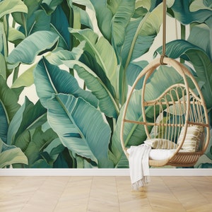 May include: A hanging wicker chair with a white throw blanket, set against a backdrop of a tropical banana leaf wallpaper.