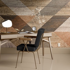 May include: A modern home office setup featuring a wooden desk with a round lamp and a black chair with gold-colored metal legs. The background is a geometric pattern in shades of brown and beige, creating a stylish workspace.