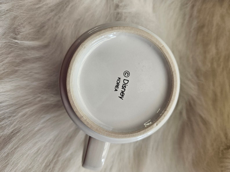 May include: White ceramic mug with a black Disney logo and "Korea" printed on the bottom.
