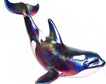 May include: A ceramic figurine of an orca whale with iridescent blue, purple, and green paint. The whale is in a leaping pose with its tail raised.
