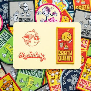 May include: A collection of colourful embroidered patches with various designs, including a cat with a helmet, a roller skater, a star, and text that says "Rocketlolly Jammers".