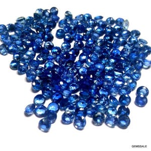 Pu&ograve; includere: Un grande mucchio di pietre preziose rotonde blu sciolte. Le pietre preziose sono tutte di dimensioni e forma approssimativamente uguali.