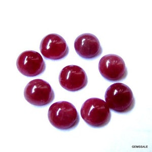 Könnte beinhalten: Zehn runde, rote Edelstein-Cabochons, jeder mit einer glatten, polierten Oberfläche. Die Cabochons sind in einem Kreis auf einem weißen Hintergrund angeordnet.