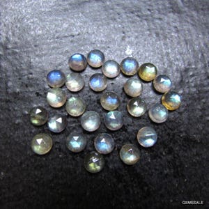 Puede incluir: Una colecci&oacute;n de 20 cabujones de labradorita, piedras preciosas iridiscentes. Las piedras son redondas y tienen un corte facetado. Son de una mezcla de colores azul claro, gris y verde.