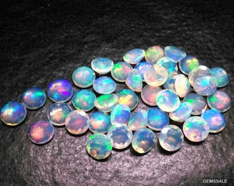 May include: A collection of iridescent opal gemstones in various sizes and shapes. The opals are a mix of white, blue, and green hues.