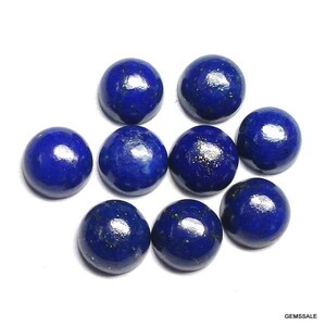 Pu&ograve; includere: Nove pietre preziose rotonde di lapislazzuli blu scuro lucido. Ogni pietra ha una superficie liscia e bombata con macchie d'oro. Le pietre preziose sono disposte su uno sfondo bianco, mostrando il loro ricco colore e la loro consistenza.