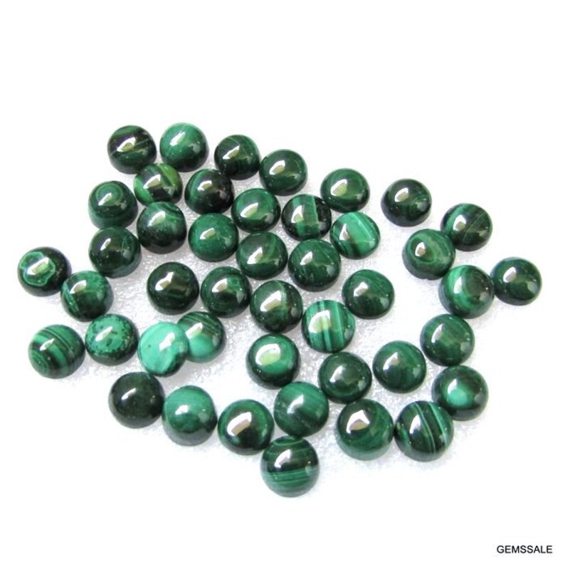 May include: A collection of 30 round, green malachite cabochons. The cabochons are smooth and polished, with a variety of green shades and patterns.