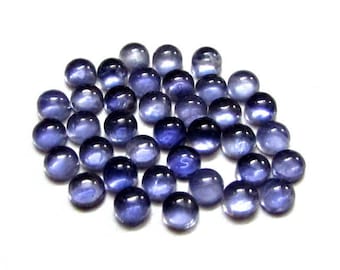 May include: A collection of round, faceted, blue-purple gemstones. The stones are smooth and polished, with a slight shimmer.