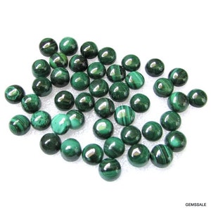 May include: A collection of 30 round, green malachite cabochons. The cabochons are smooth and polished, with a variety of patterns and swirls.
