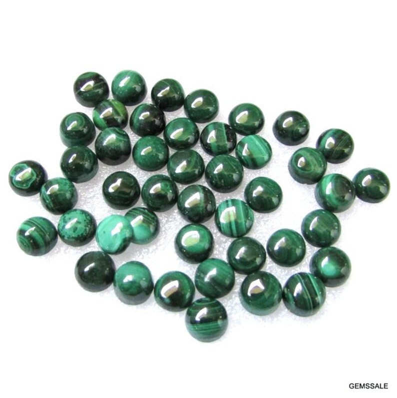 May include: A collection of 30 round, green malachite cabochons. The cabochons are smooth and polished, with a variety of patterns and swirls.