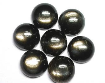 Könnte beinhalten: Sieben runde, schwarze Edelstein-Cabochons mit goldenem Schimmer. Die Cabochons sind kreisförmig angeordnet.