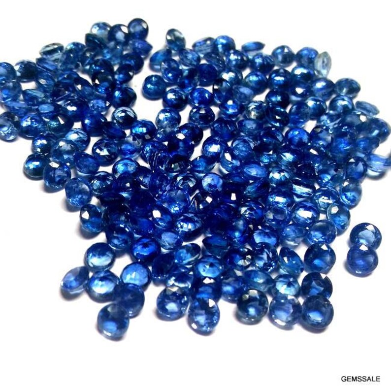 Pu&ograve; includere: Un grande mucchio di pietre preziose di zaffiro blu sfaccettate. Le pietre preziose sono rotonde e hanno una finitura liscia e lucida.