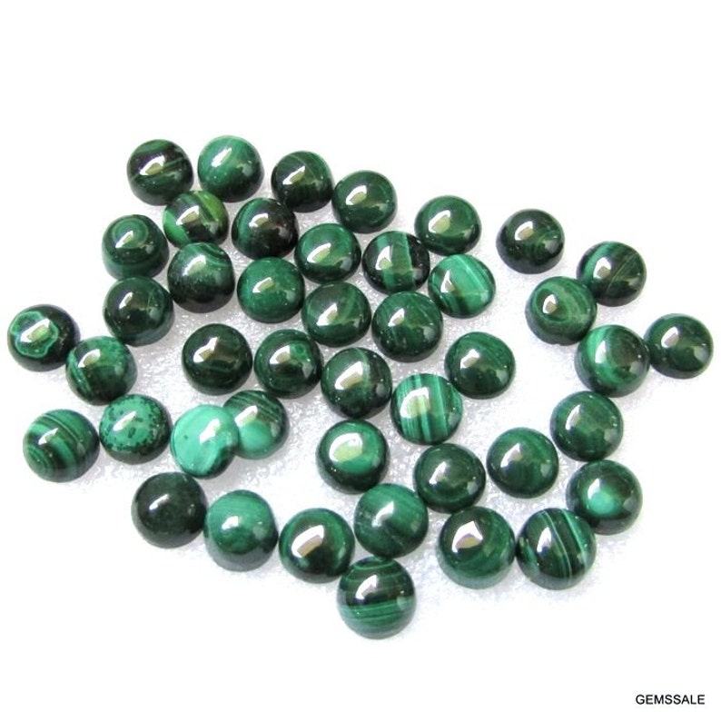 May include: A collection of 30 round, green malachite cabochons. The cabochons are smooth and polished, with a variety of green shades and patterns.