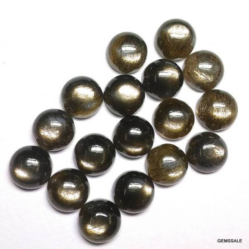 May include: A collection of 15 round, black and gold gemstone cabochons. The cabochons have a smooth, polished surface and a shimmering, iridescent effect.