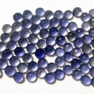 May include: A collection of 50 round, faceted, purple amethyst gemstones. The stones are approximately 6mm in diameter and have a smooth, polished finish.