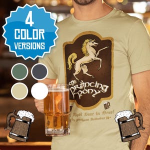 Könnte beinhalten: Ein beiges T-Shirt mit einer braunen und gelben Grafik eines weißen Pferdes mit dem Text "The Prancing Pony" und "The Best Beer in Bree! By Barliman Butterbur"