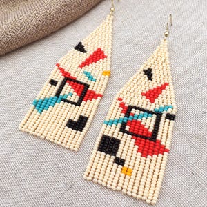 Abstract geometric seed bead earrings inspired by Bauhaus design, featuring ivory, black, red and turquoise color blocks with 18K gold-plated ear hooks.