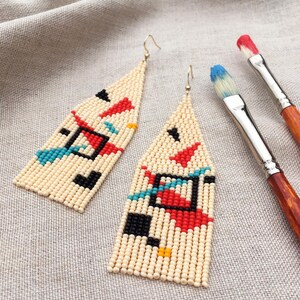 Abstract geometric seed bead earrings inspired by Bauhaus design, featuring ivory, black, red and turquoise color blocks with 18K gold-plated ear hooks.