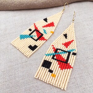 Abstract geometric seed bead earrings inspired by Bauhaus design, featuring ivory, black, red and turquoise color blocks with 18K gold-plated ear hooks.