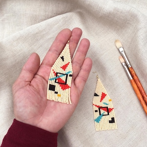 Abstract geometric seed bead earrings inspired by Bauhaus design, featuring ivory, black, red and turquoise color blocks with 18K gold-plated ear hooks.