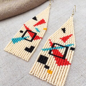 Abstract geometric seed bead earrings inspired by Bauhaus design, featuring ivory, black, red and turquoise color blocks with 18K gold-plated ear hooks.