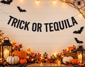 May include: A black glittery banner with the text TRICK OR TEQUILA suspended against a white wall. The scene includes orange and white pumpkins, two black lanterns with lit candles, autumn leaves, string lights, and black paper bats.