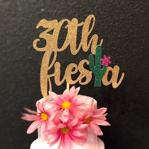 May include: Gold glitter cake topper with the text "30th Fiesta" and a green cactus with a pink flower.