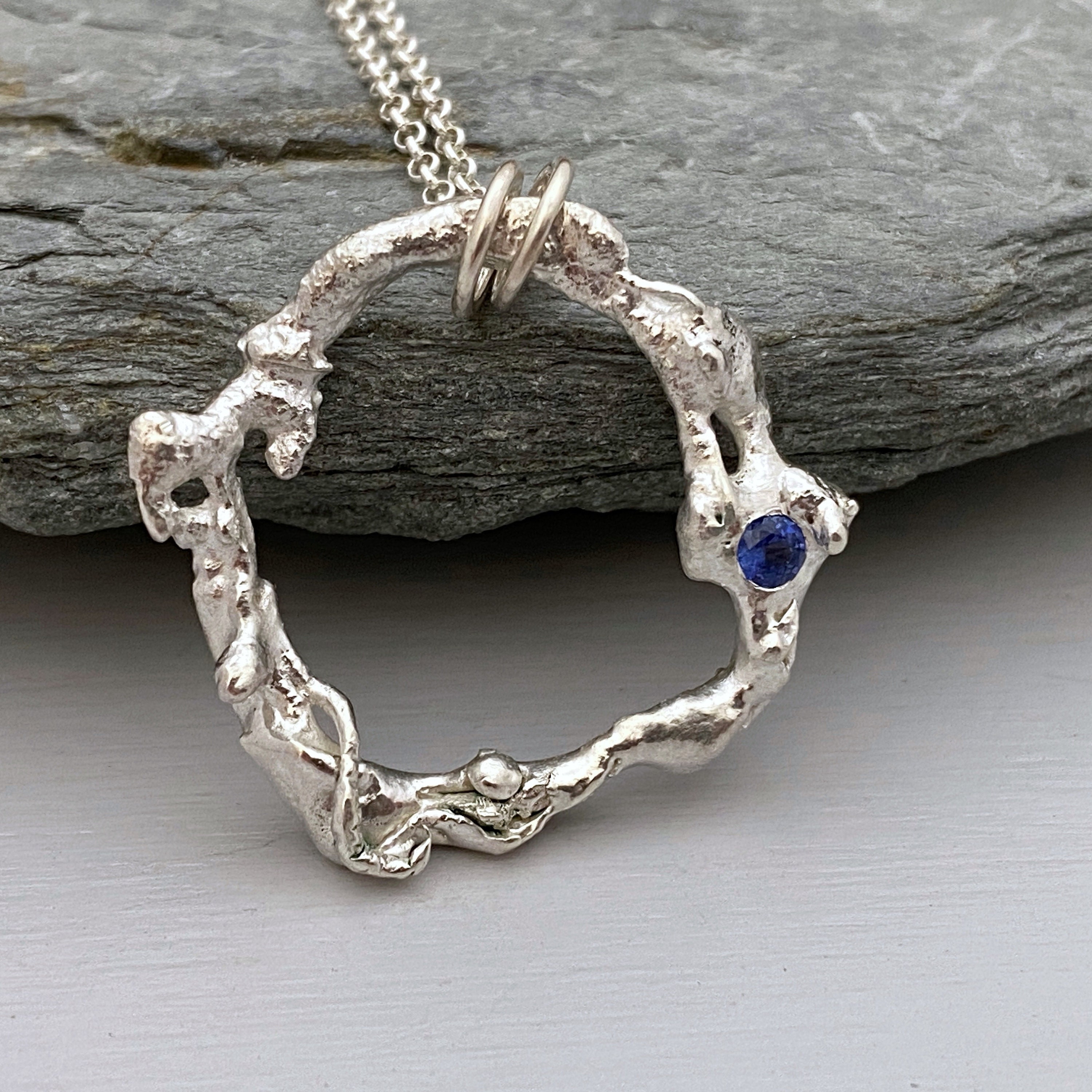 Molten Silver Circle Necklace Set With A Cornflower Blue Sapphire Gemstone, Organic Pendant