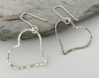 Heart shaped dangly earrings handmade from hammered silver.