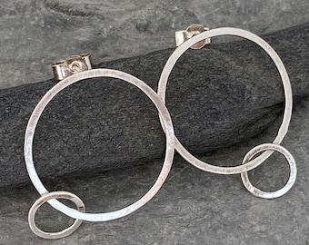 Large silver hoop earrings with a matt brushed finish or a sparkly hammered finish. Round silver stud earrings with a small silver ring link