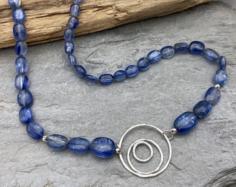 Bold statement necklace made from blue kyanite beads with a silver circles pendant detail. One of a kind necklace