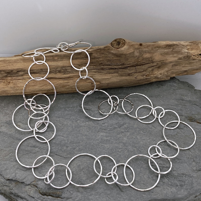 Hammered silver chain necklace made from round open links in three sizes and fastened with a hallmarked hook