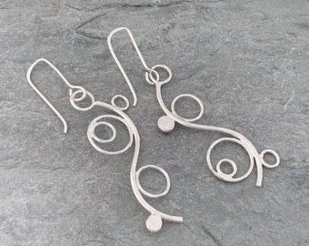 Long dangly silver earrings with an asymmetrical style, handmade from recycled sterling silver