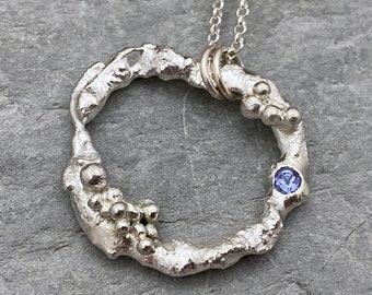 Molten silver circle necklace set with Tanzanite gemstone, organic silver pendant