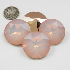 May include: Four round, faceted, iridescent pink glass buttons. The buttons have a gold-toned backing.