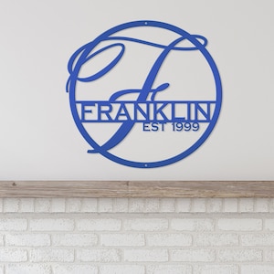 May include: Blue metal monogram sign with a cursive "F" in a circle. The name "FRANKLIN" and "EST 1999" are below the circle.