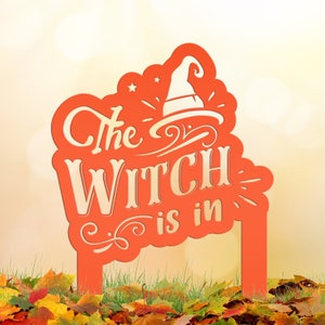 May include: Orange metal Halloween yard sign with the text "The Witch is in" and a witch's hat silhouette.