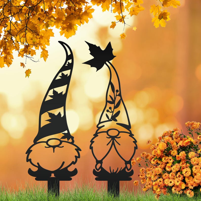 May include: Two black metal garden gnomes with tall, pointed hats. One hat has diagonal stripes and leaf cutouts, the other has a leaf at the top. They are set in a grassy area with an orange and yellow background.