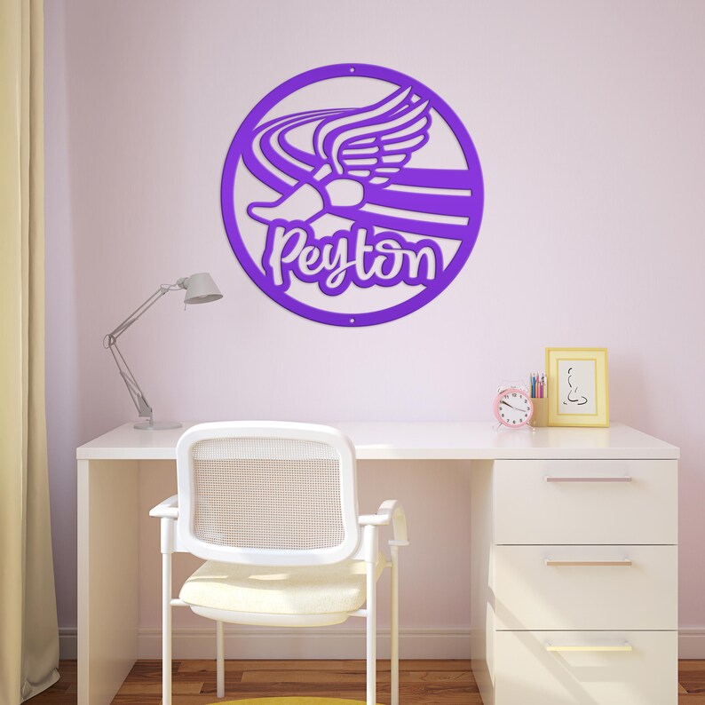 Puede incluir: Un letrero de pared circular de color morado con un dise&ntilde;o recortado de una zapatilla de correr alada y el nombre Peyton en letra cursiva. El letrero tiene dos peque&ntilde;os orificios en la parte superior e inferior para su montaje.