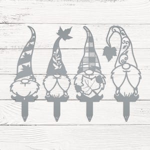 May include: Four gray metal garden gnomes with different hat designs. Each gnome has a stake at the bottom for easy placement in a garden or flower bed. The hats feature leaf and plaid patterns.