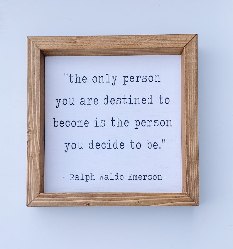May include: A framed wood sign with a white background and black text. The text reads "the only person you are destined to become is the person you decide to be."  The text is attributed to Ralph Waldo Emerson.