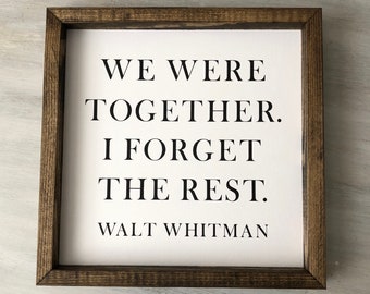 May include: A framed wood sign with a white background and black text that reads "We were together. I forget the rest. Walt Whitman".