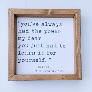 May include: A framed wood sign with a white background and black text. The text reads "you've always had the power my dear, you just had to learn it for yourself."  The text is attributed to Glinda, The Wizard of Oz.