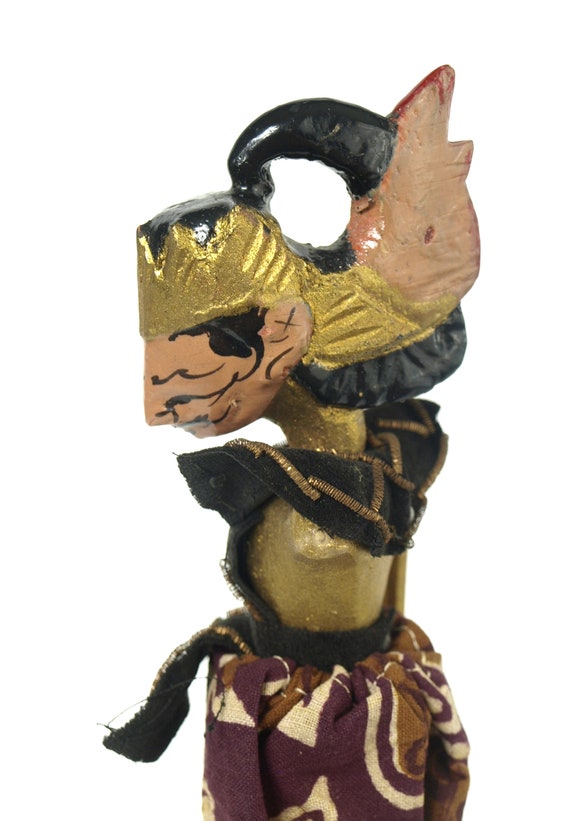 木製の台座に置かれたインドネシアのヴィンテージ影絵人形 - 片腕は