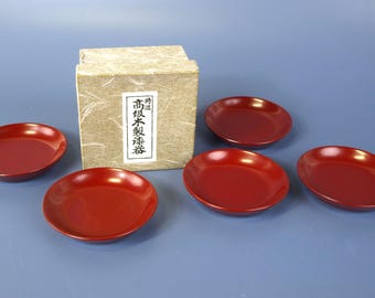 Set vintage di 5 piattini individuali per dolci in lacca rossa giapponese, risalenti agli anni '50 circa, nella scatola originale e in perfette condizioni.