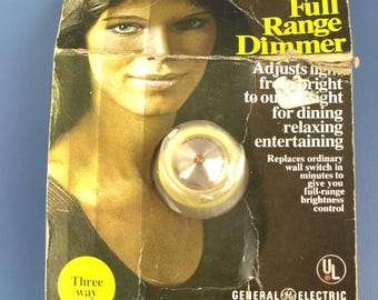 Interruptor de luz redondo regulador de tres vías GE vintage, modelo DI-63ULD, en su embalaje original (NOS)