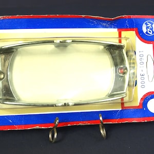 May include: A vintage rectangular automotive light fixture with a chrome finish, packaged on a blue, red, and yellow cardboard backing. The package includes the text "K-D Lamp Co." and the product code "10601-3000".