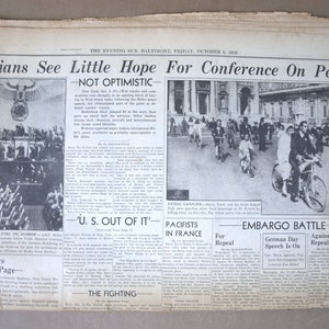May include: A black and white newspaper clipping from October 4, 1929, with the headline "Italians See Little Hope For Conference On Peace." The article discusses the lack of optimism surrounding the peace conference. The newspaper also includes a photo of a wedding couple riding bicycles, with the caption "Saving Gasoline." The article also discusses the "Embargo Battle" and the "Pacifists in France."